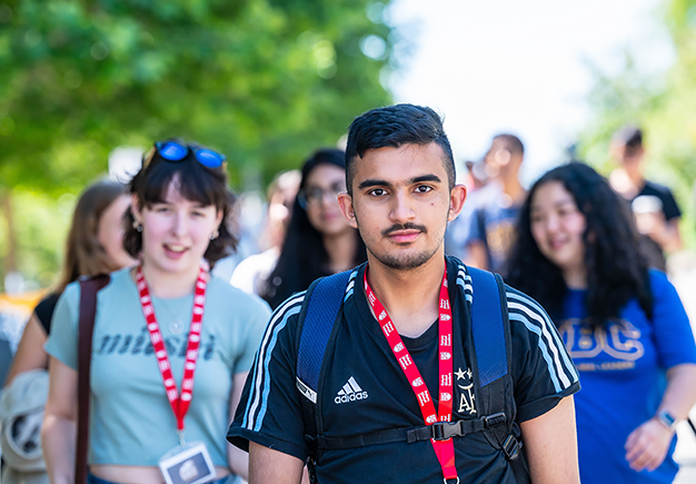 Two males and one female student walking together, chatting