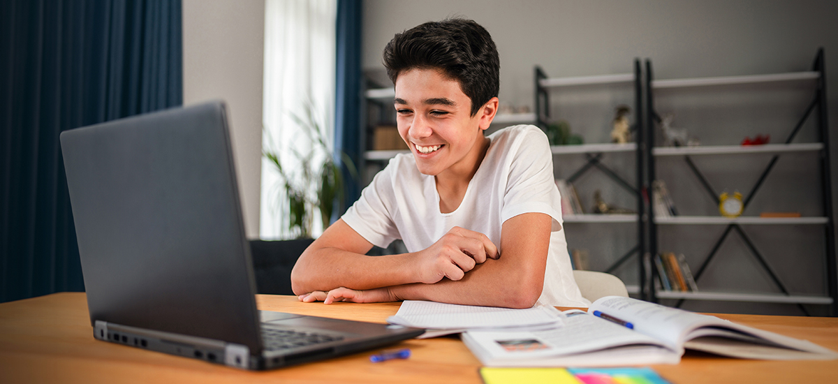 male student studying on a laptop at home