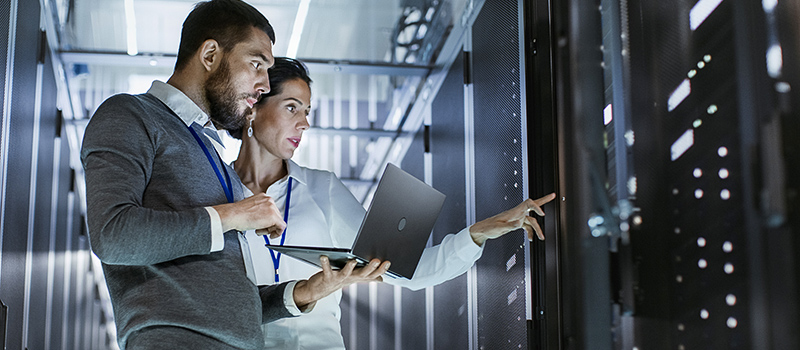 Two people in a server room.